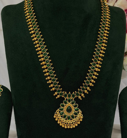 Close-up of South Indian long necklace with green teardrop stones and ornate pendant