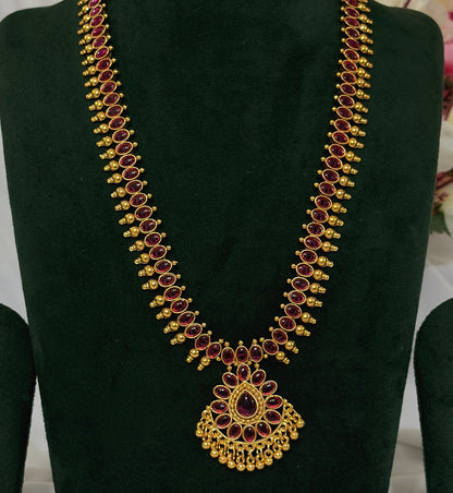 Close-up of South Indian long necklace with red teardrop stones and ornate pendant