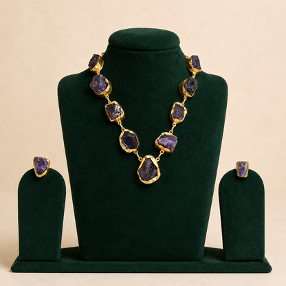 Brass and uncut amethyst statement necklace displayed on green velvet