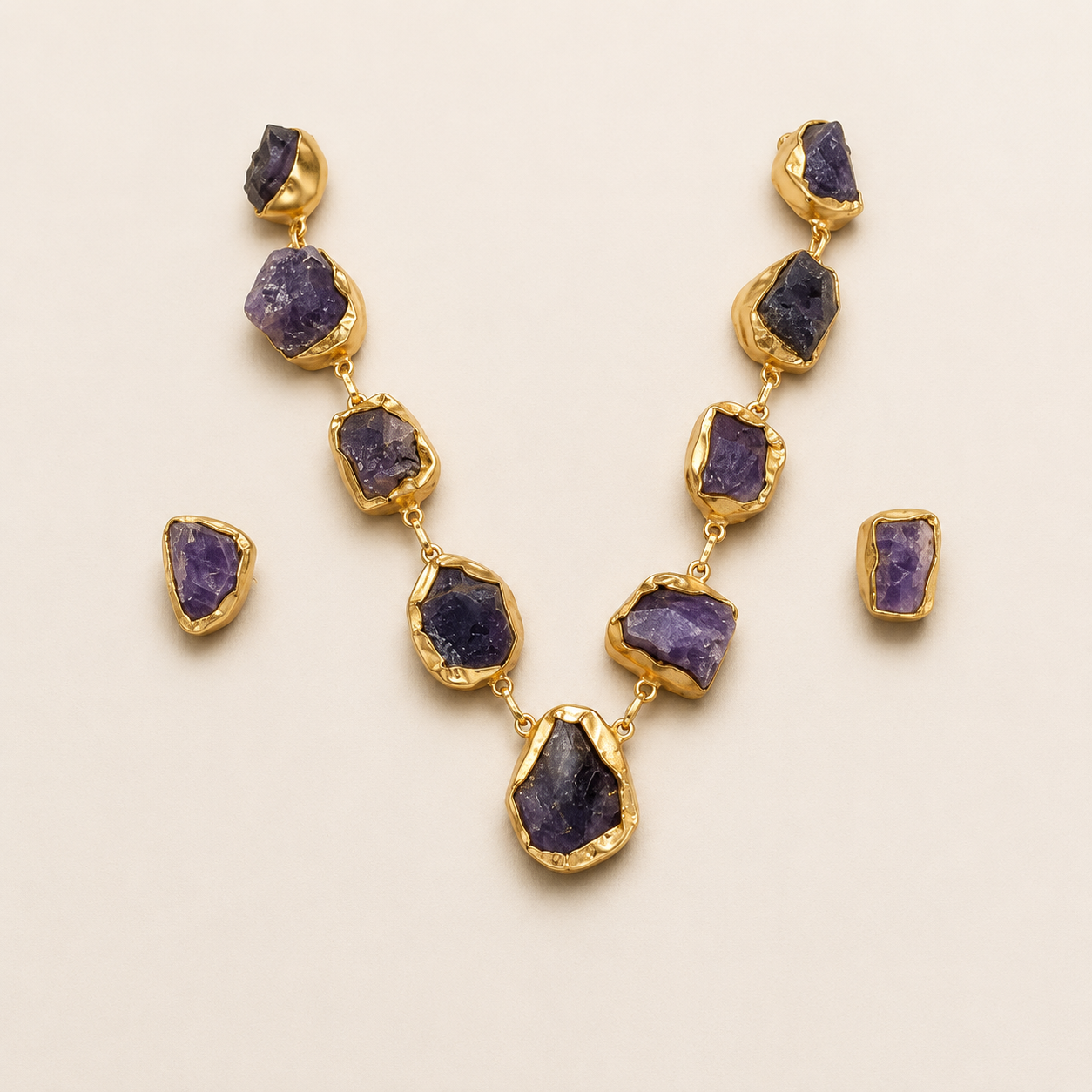 Uncut amethyst brass necklace and earrings on an ivory background